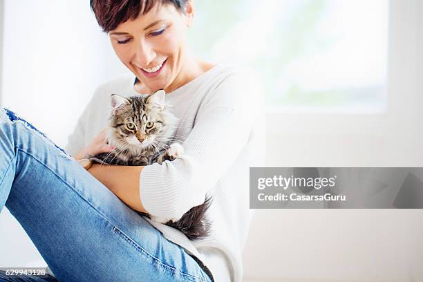happy woman portrait mit ihrer katze - zärtlich stock-fotos und bilder