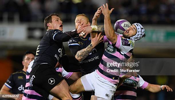Jack Wilson and Tom Homer of Bath and Matthew Morgan of Blues contest a high ball during the European Rugby Challenge Cup match between Bath Rugby...
