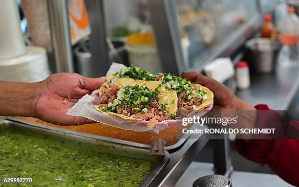 People eat at one of the many stalls selling street meals in Mexico City, on December 15, 2016. In spite of numerous campaigns to combat overweight...