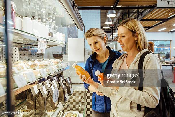 purchasing healthy refreshments - vergelijking stockfoto's en -beelden