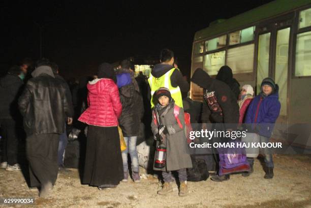 Syrians, who were evacuated from rebel-held neighbourhoods in the embattled city of Aleppo, arrive in the opposition-controlled Khan al-Aassal...