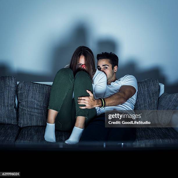 pareja joven viendo películas de terror - scary movie fotografías e imágenes de stock