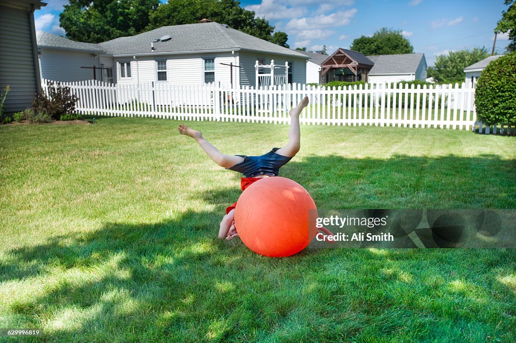 Boy bouncing on Orange Ball