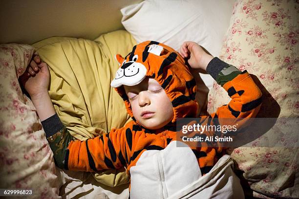 Boy sleeps wearing tiger costume