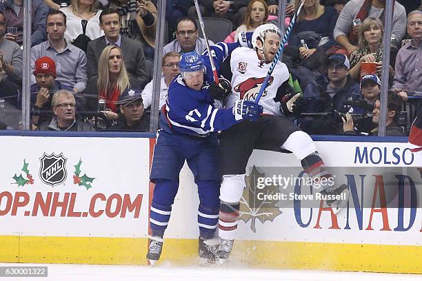 Toronto Maple Leafs center Leo Komarov checks Arizona Coyotes defenseman Alex Goligoski as the Toronto Maple Leafs play the Arizona Coyotes at the...