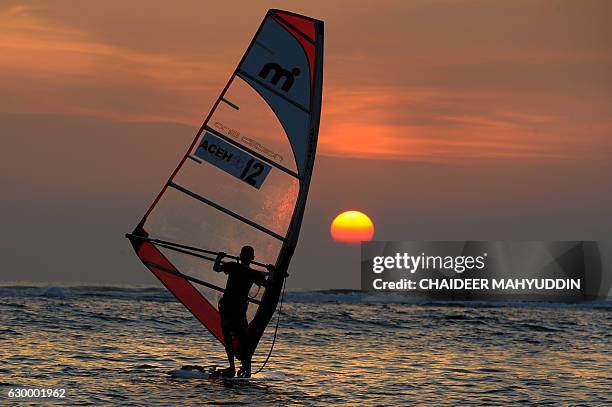 In this photograph taken on December 15, 2016 an Acehnese windsurfs at Lhoknga, in Aceh province. Lhoknga is one of Aceh west coast area which was...