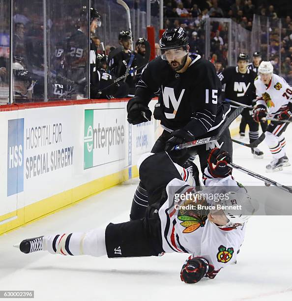 Brian Campbell of the Chicago Blackhawks is checked by Cal Clutterbuck of the New York Islanders during the second period at the Barclays Center on...