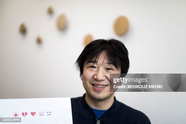 Japanese Shigetaka Kurita, the man who created emoji charachters, gestures next to the emoji charachters during an interview with AFP in Tokyo on...