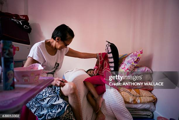 In this photo taken on December 13 four-year-old Keana and her elderly grandmother Rosalina play in the bedroom of the flat that they live in with...