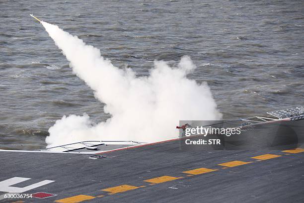 This picture taken on an undisclosed date in December 2016 shows a missile being fired from the Liaoning aircraft carrier during military drills in...