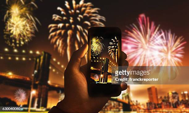 smartphone nehmen sie ein foto von der nyc-feier - firework display stock-fotos und bilder