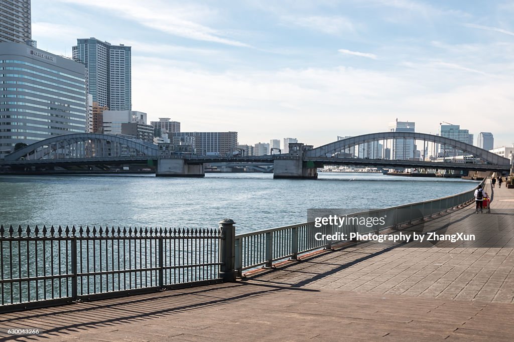 Kachidoki bridge and skyscrapers, walking road in Tokyo Chuo ward beside Sumida river at day time.