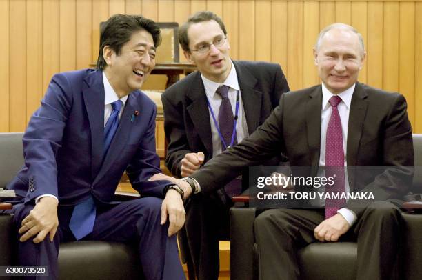 Russian President Vladimir Putin chats with Japanese Prime Minister Shinzo Abe during a visit to the Kodokan judo hall in Tokyo on December 16, 2016....