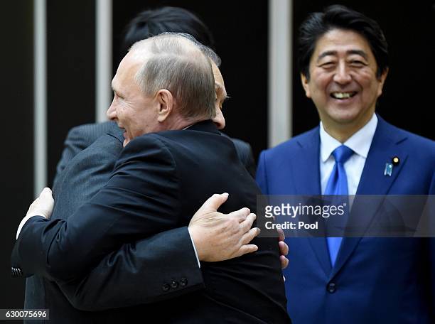 Russian President Vladimir Putin is welcomed by former Japanese Prime Minister Yoshiro Mori beside Japanese Prime Minister Shinzo Abe when he visits...