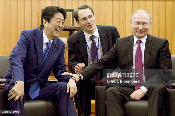 Vladimir Putin, Russia's president, right, reacts with Shinzo Abe, Japan's prime minister, left, while he visits the Kodokan Judo Institute in Tokyo,...