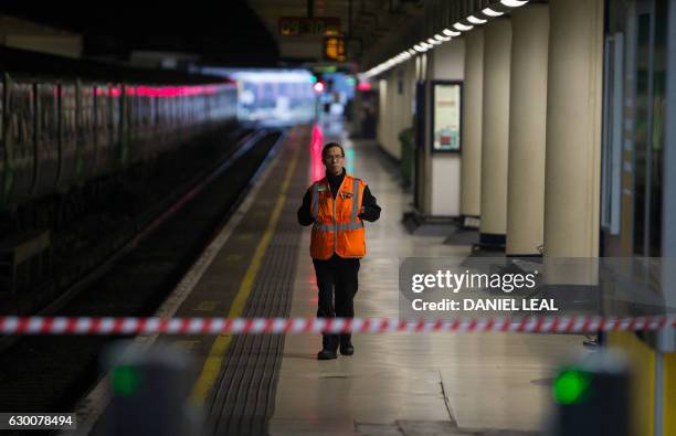 Southern Rail employee walks along an empty platform at Victoria station in London on December 16, 2016. - Hundreds of thousands of commuters were...
