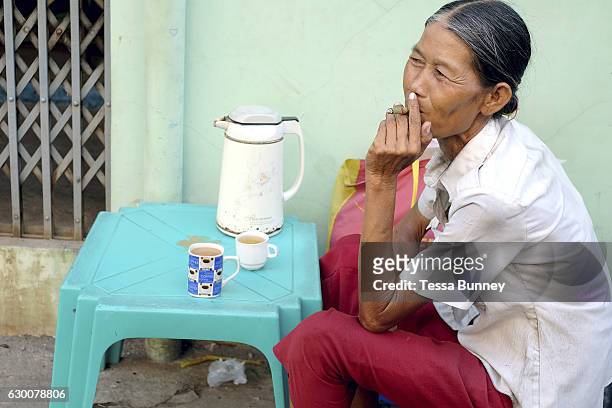 Woman smokes a cheroot at a tea shop on the streets of Yangon on 18th May 2016 in Myanmar