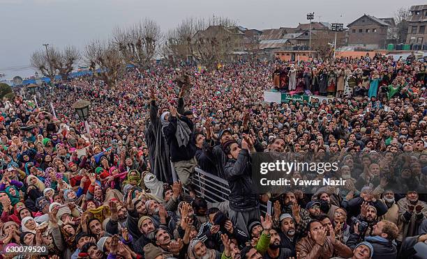 Kashmiri Muslim devotees look towards a cleric displaying the holy relic believed to be the whisker from the beard of the Prophet Mohammed, at...