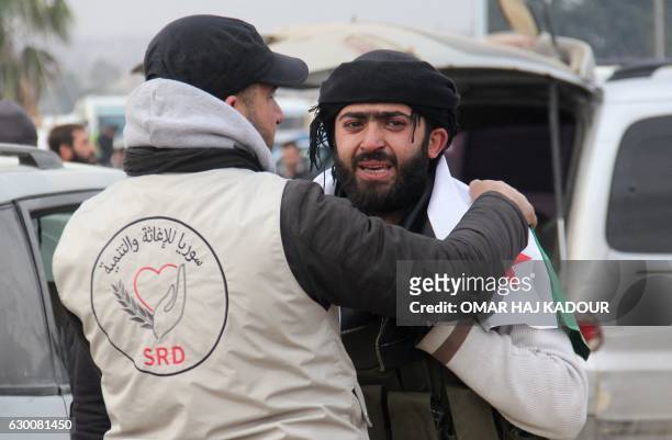 Member of a Syrian NGO comforts a man who was evacuated from rebel-held neighbourhoods in the embattled city of Aleppo upon his arrival in the...