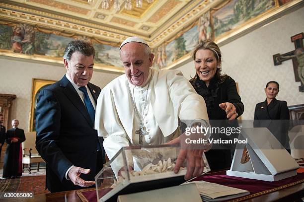 Pope Francis exchanges gifts with Colombia President Juan Manuel Santos Calderon and wife Maria Clemencia Rodriguez de Santos during an audience at...