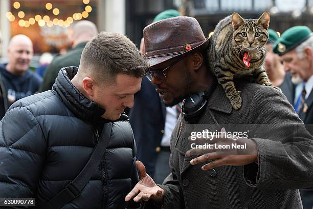 Founder of the English Defence League Tommy Robinson talks to a man with a cat outside the High Court as the bail hearing for marine Alexander...