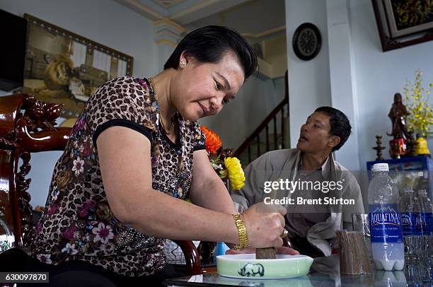 Wealthy Vietnamese woman sits and grinds Rhino horn for her personal consumption in a roadside cafe in Baoloc, Vietnam on October 6, 2011. The dealer...