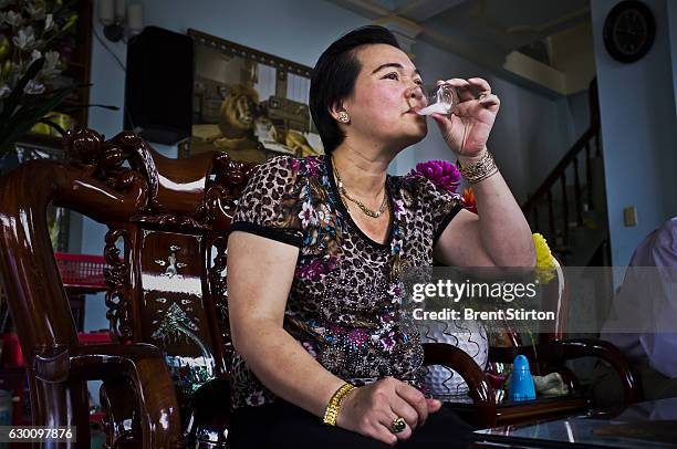 Wealthy Vietnamese woman sits and grinds Rhino horn for her personal consumption in a roadside cafe in Baoloc, Vietnam on October 6, 2011. The dealer...
