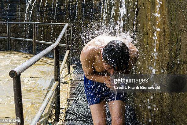 Male pilgrim is having a shower for purifying body and soul by running through the 108 holy wells.