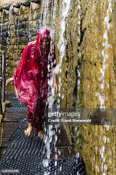 Female pilgrim is having a shower for purifying body and soul by running through the 108 holy wells.