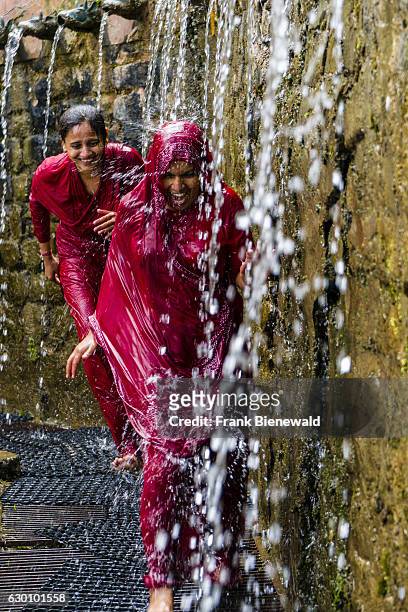 Two female pilgrims are having a shower for purifying body and soul by running through the 108 holy wells.