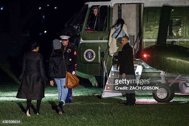 President Barack Obama boards Marine One with First Lady Michelle Obama, back left, and his daughters, Sasha and Malia, in Washington, DC on December...