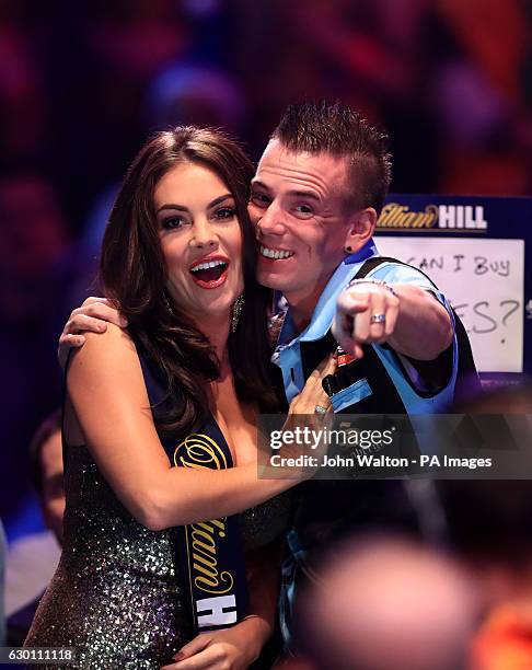 Jerry Hendriks shares a joke with the William Hill walk on girl before the start of his match against Peter Wright during day two of the William Hill...