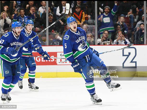 Sven Baertschi and Bo Horvat help Luca Sbisa of the Vancouver Canucks celebrate a goal against the Tampa Bay Lightning during their NHL game at...