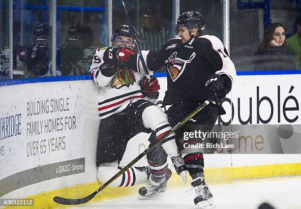 Ty Ronning of the Vancouver Giants check Evan Weinger of the Portland Winterhawks into the end boards during the third period of their WHL game at...