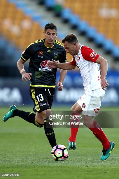 Scott Neville of Western Sydney is put under pressure from Marco Rossi of Wellington header the ball during the round 11 A-League match between...