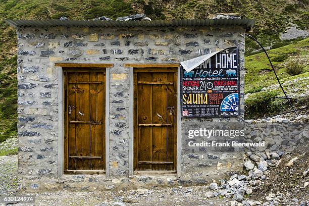 Small hut with 2 doors outside of Muktinath with a Russian Sauna advertisement.