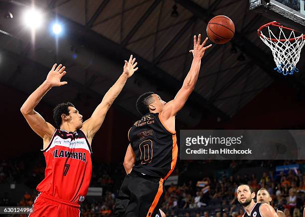 Travis Trice of the Taipans attempts a lay up past Oscar Forman of the Hawks during the round 11 NBL match between Cairns and Illawarra on December...