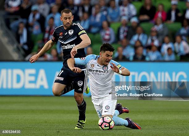 Bruno Fornaroli of Melbourne City is is challenged by Carl Valeri of the Victory during the round 11 A-League match between Melbourne City FC and...