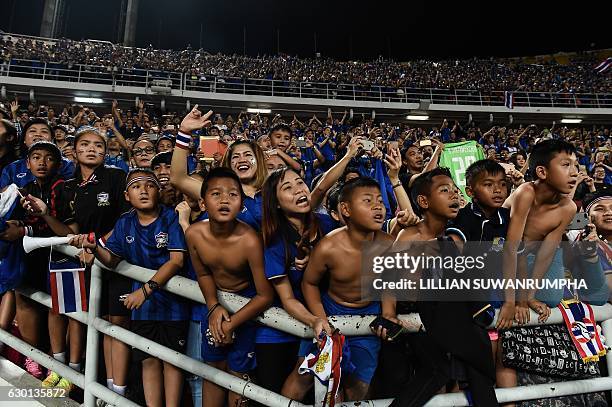 Thai football fans celebrate after Thailand won the AFF Suzuki Cup Final between Thailand and Indonesia at Rajamangala Stadium in Bangkok on December...