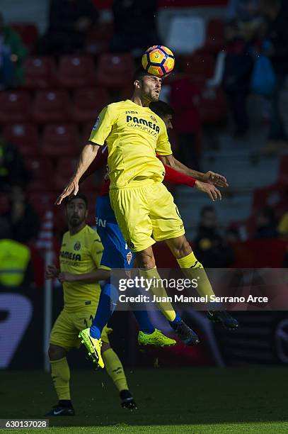 Victor Ruiz of Villarreal CF duels for the ball with Carlos Carmona of Real Sporting de Gijon during the La Liga match between Real Sporting de Gijon...