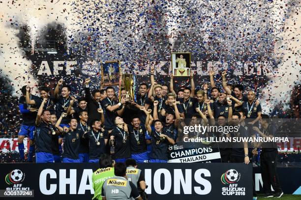 Thailand's football players lift the AFF Suzuki Cup after winning the second leg of the final between Thailand and Indonesia 2-0 at Rajamangala...