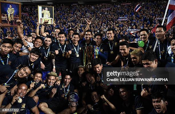 Thailand's football players and staff celebrate in front of a home crowd after winning the AFF Suzuki Cup final between Thailand and Indonesia 2-0 at...