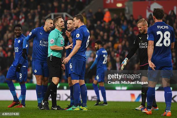 Referee Criag Pawson argues with Robert Huth of Leicester City during the Premier League match between Stoke City and Leicester City at Bet365...