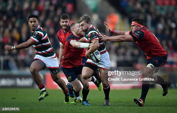 Jack Roberts of Leicester Tigers breaks from Keith Earles and C J Stander of Munster during the European Rugby Champions Cup match between Leicester...