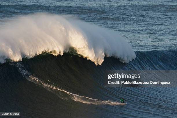 British surfer Andrew Cotton rides a big wave at Praia do Norte on December 17, 2016 in Nazare, Portugal. Nazare's giant waves are increasingly...