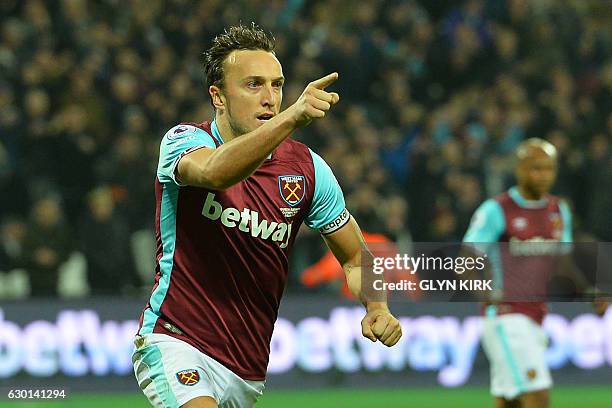 West Ham United's English midfielder Mark Noble celebrates after scoring the opening goal from the penalty spot during the English Premier League...