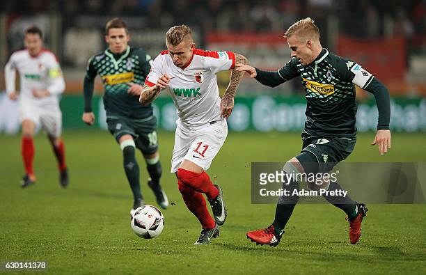 Oscar Wendt of Borussia Moenchengladbach challenges Jonathan Schmid of Augsburg during the Bundesliga match between FC Augsburg and Borussia...
