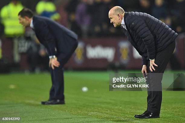 Hull City's English manager Mike Phelan and West Ham United's Croatian manager Slaven Bilic react on the touchline during the English Premier League...