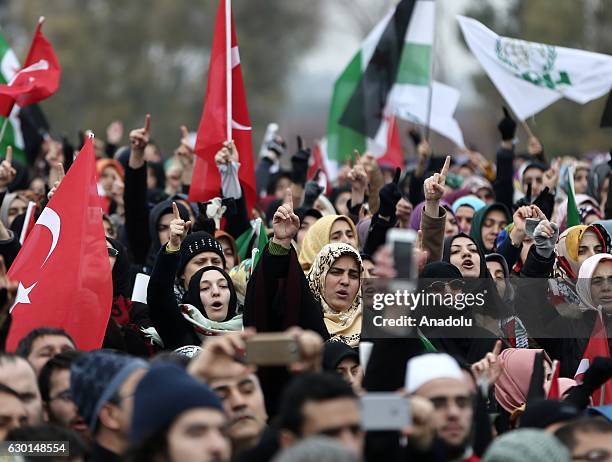 People take part in a protest against Assad regime forces' and its supporters' attacks on civilians and the humanitarian plight, as people come...