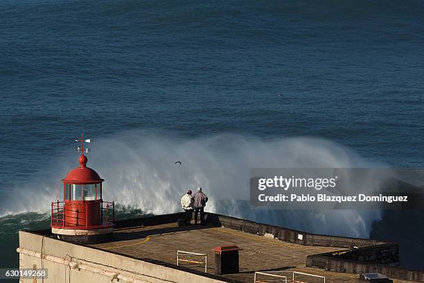 Members of the public watch big waves during a surfers big wave session at Praia do Norte on December 17, 2016 in Nazare, Portugal. Nazare's giant...